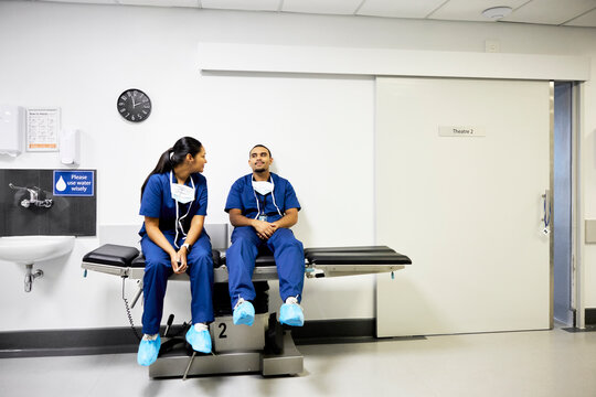 Two Doctors Sit in a Hospital Waiting Area