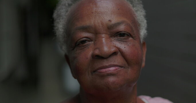African American elderly woman outdoors close up looking at camera with calm reflective expression conveying dignity resilience life experience wisdom and quiet inner strength