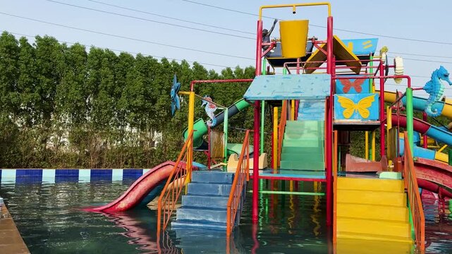 outdoor kids water amusement zone with colorful play structure and pool
