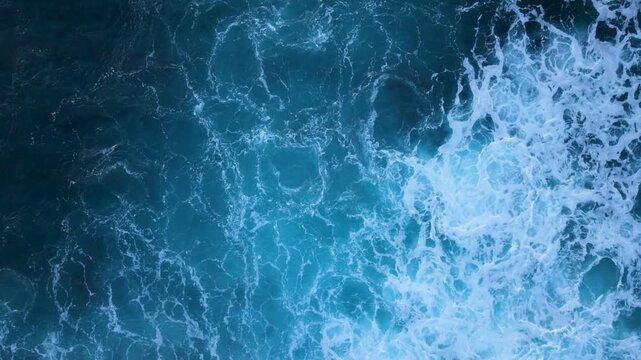 A top view shows sea foam moving in slow motion, clear background and copy space for text