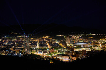 Fototapeta premium City skyline at night with skyscraper light beams