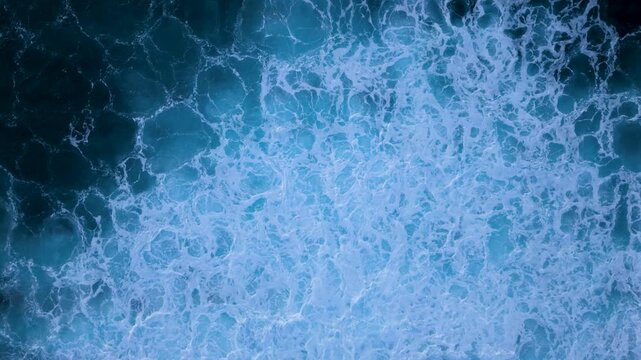 Aerial view shows waves crashing in slow motion, background with copy space