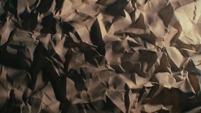 Crumpled brown paper shown in textured style on a neutral background, concept of roughness and creativity