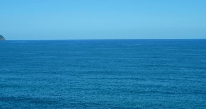 Vast Blue Ocean Horizon: An expansive view of the deep blue ocean stretching towards the horizon under a clear, cloudless sky, evoking a sense of tranquility and infinite possibility.