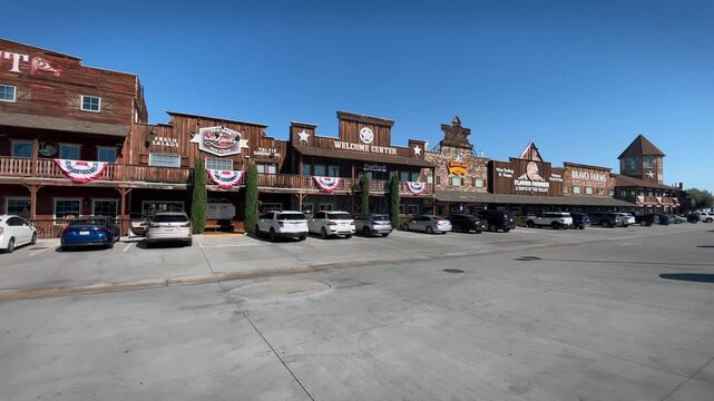 Handheld 4K footage moves forward from the parking lot toward the colorful two-story themed entrance facade of Bravo Farms in California, fully decorated with logos, signage and rustic farm themed orn