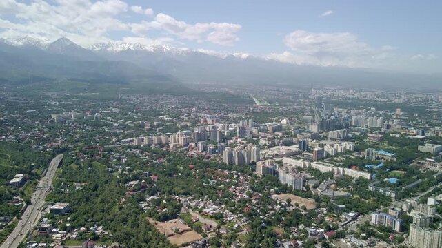 Stunning aerial view of Almaty city skyline with snowy mountain peaks, Kazakhstan