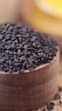 Explore black cumin seeds in a wooden bowl on a table