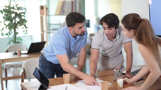 Colleagues work on paper drawing, making sketches while discussing construction plan. High quality 4k footage