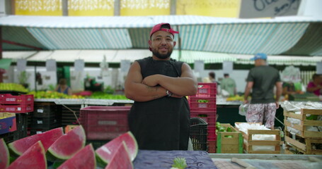Fototapeta premium Hispanic street vendor with crossed arms at busy outdoor market expressing confidence resilience local food trade and everyday working life in urban community space