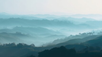 Naklejka premium Misty blue mountain range at sunrise. Layered hills covered in morning fog. Scenic landscape view of valley and forest. Calm nature atmosphere for travel background and meditation.