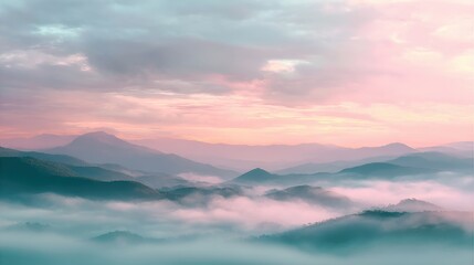 Obraz premium Misty mountain range at sunrise. View of valley covered with fog during dawn. Serene landscape with pink clouds and soft light. Beautiful natural scenery for travel and vacation themes.