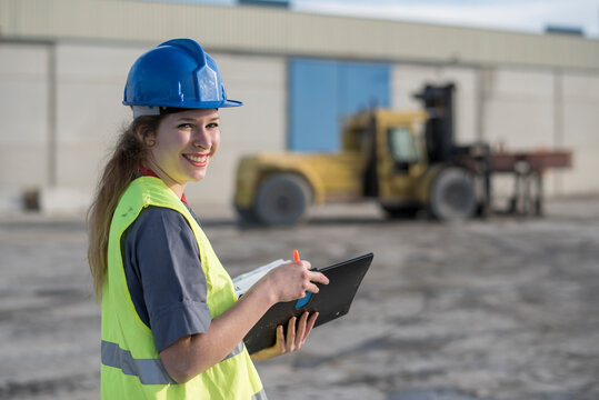 Female construction worker looking at camera and smiling in outdoors image. Cordoba, Spain.