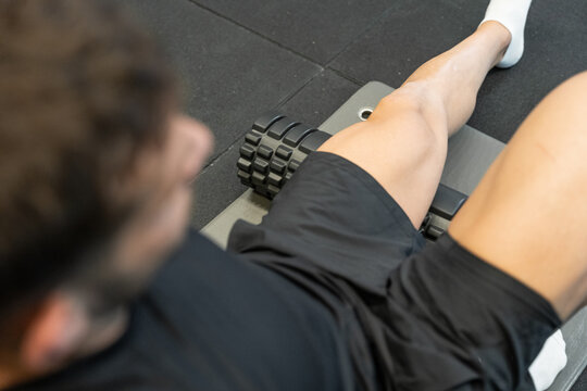 Man foam rolling leg muscles for post workout recovery