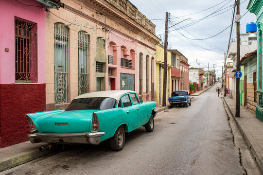 Turquoise vintage car on a colorful colonial street in Cuba.