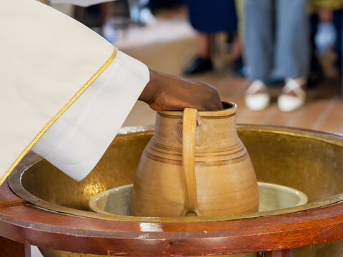 Rite du bapt&ecirc;me chr&eacute;tien avec versement de l&rsquo;eau b&eacute;nite sur les fonts baptismaux lors d&rsquo;une c&eacute;r&eacute;monie religieuse