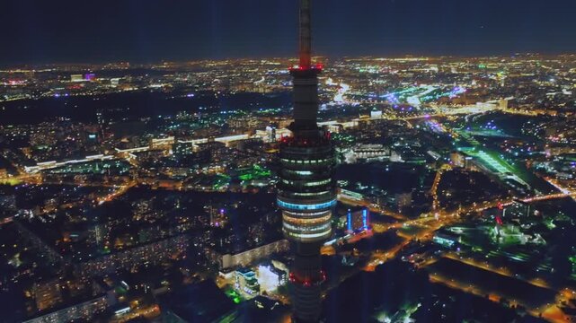 Aerial view of the illuminated Ostankino Tower against the backdrop of the Moscow cityscape at night