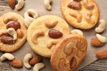 Naklejka premium Tasty cookies with nuts on wooden table, flat lay