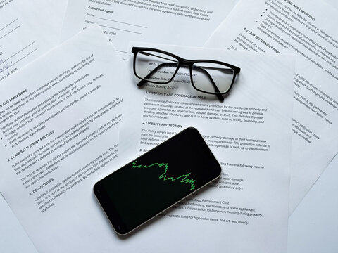 Financial Documents with Trading App Phone - Investment Strategy Analysis