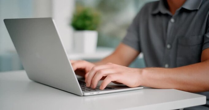 Close up side view of young man hands typing on laptop keyboard working in modern office.