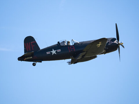MLADA BOLESLAV, CZECH REPUBLIC - JUNE 13, 2026: Historic Chance Vought F4U Corsair fighter aircraft performing a banking dynamic flyby during an airshow against a clear blue sky background.