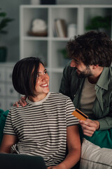 Smiling couple shopping online with credit card, enjoying digital banking and e commerce from home
