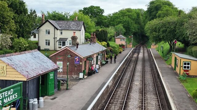 Hampshire England UK. 03.06.2026. Video. A picturesque vintage train station platform featuring  traditional classic railway tracks under a cloudy sky