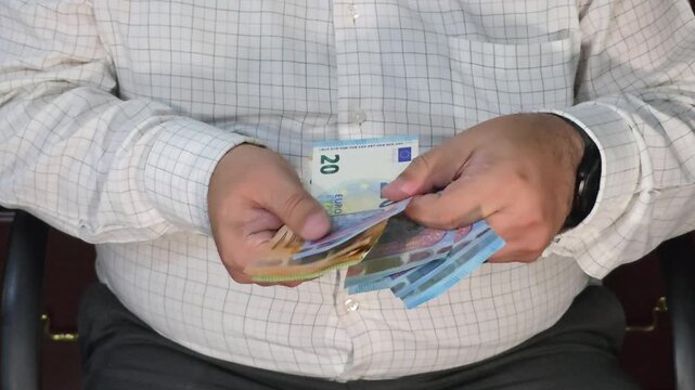 Businessman hands counting euro banknotes of various denominations