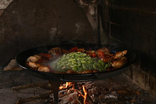 Traditional Valencian paella cooking in wood fired oven