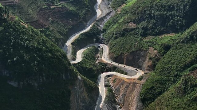 A Group of Bikers on Motorcycles riding the winding road of Ma Pi Leng Pass in Vietnam. A Part of a Famous Ha Giang Loop