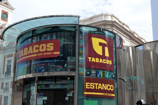 MADRID, SPAIN - JUNE, 4, 2026. Tabacos estanco glass kiosk exterior with red and yellow signage on city street for storefront and street scene photography