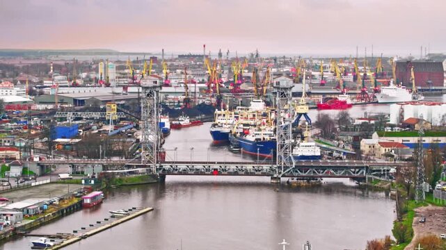 Double leaf bascule bridge lifting to allow boat traffic in an industrial harbor over a river