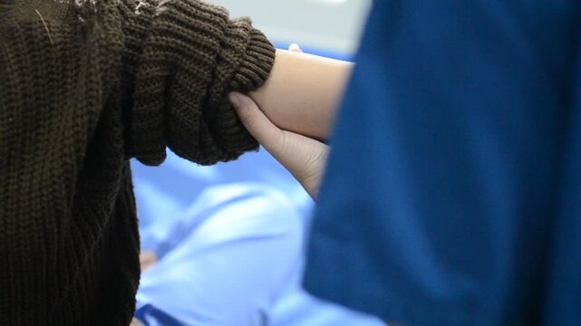 Physical therapist examining patient's elbow and wrist
