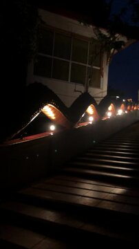 Panning up an ornate Naga banister over a staircase leading up to a golden Buddha. Taken at night with dramatic lighting under the serpent giving Buddha a dramatic entry.