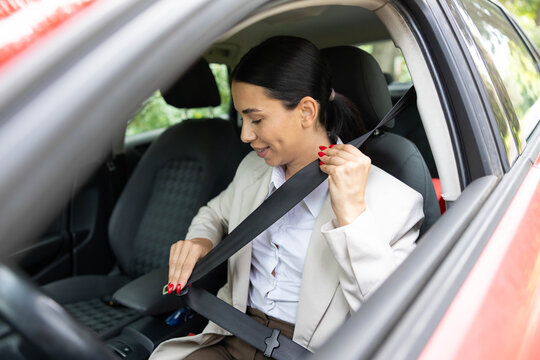 Woman fastening seatbelt in a car, prioritizing road safety before driving to work or during a daily commute
