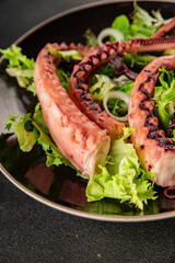Octopus dish octopus tentacle salad fresh seafood lunch or dinner tasty organic snack fresh delicious gourmet food background rustic food on a table, top view farm product copy space pescetarian diet © Alesia Berlezova