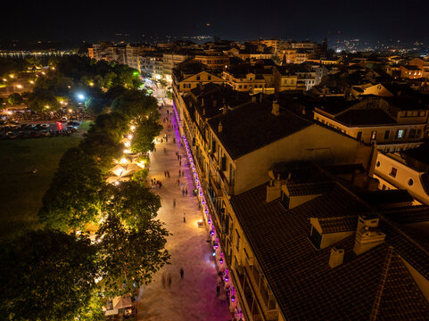 Aerial night view of the famous Liston promenade and Spianada Square filled with people during Orthodox Easter celebrations with purple lights in Corfu town, Greece