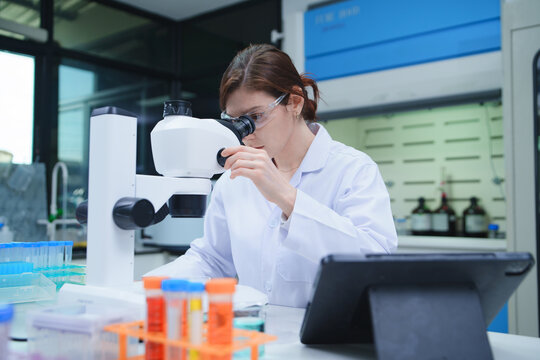 Female Scientist Using Microscope in Modern Laboratory