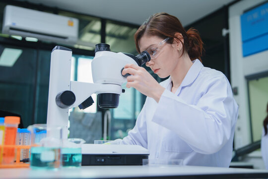 Female Scientist Conducting Research with Microscope in Laboratory