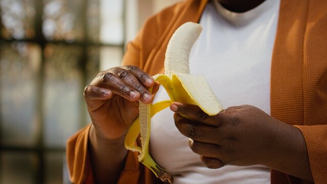 Content creator pealing a banana and adding slices on chia bowl, preparing a healthy breakfast meal for online audience.