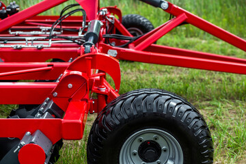 Obraz premium Red agricultural machine stands in green grass