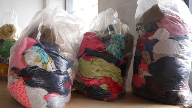 Large bags filled with donated clothes prepared for charity distribution. Humanitarian aid, social support, clothing donation, helping people in need and community assistance