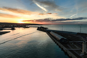 Fototapeta premium Sunset over coastal harbor with pier and calm sea, Italy, Rome 