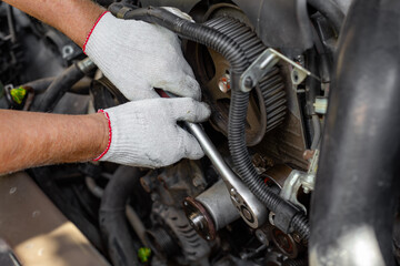 Fototapeta premium Gloved hands position a timing belt on cam gears during installation. timing belt installation, engine maintenance, professional service.