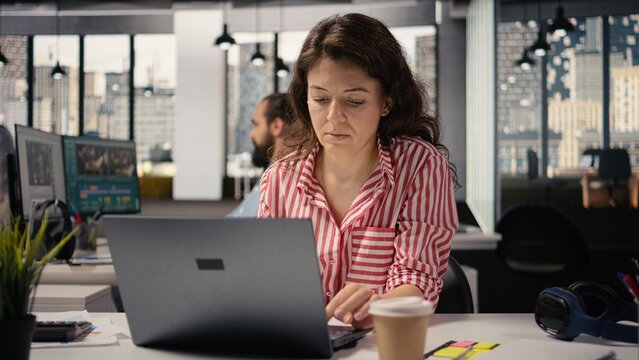Female worker, woman at desk with laptop, working in smart office corporation, providing business administration for new strategy and project growth, staff ensuring productivity startup.