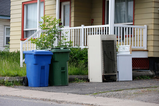 Des poubelles devant une maison &agrave; Qu&eacute;bec. Un vieux r&eacute;frig&eacute;rateur et une vieille cuisini&egrave;re dans les ordures.