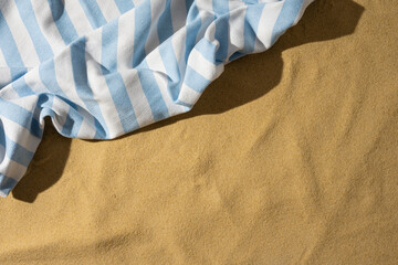 Striped beach towel on sand with space for travel essentials © ActionGP