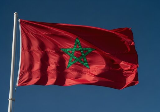 National flag of morocco waving in the wind against a clear blue sky