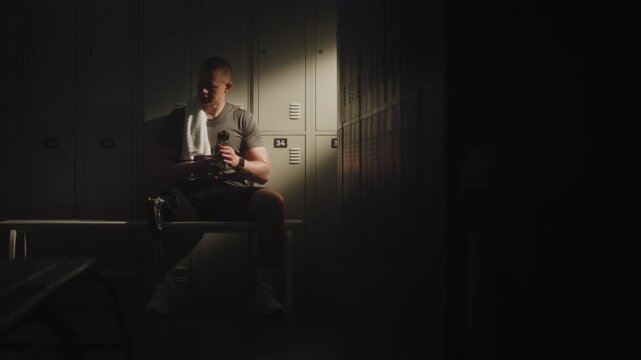 After Intense Training Session, Man Sits on Bench, Soaking in Warm Beam of Sunlight. Physical Exhaustion and Inner Strength of Resilient Athlete. Triumph of Human Spirit Over Physical Challenges.