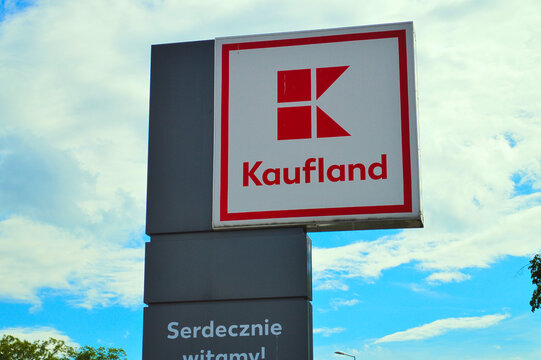 Large commercial outdoor sign post of Kaufland supermarket with Polish welcome greeting Serdecznie witamy under blue cloudy sky