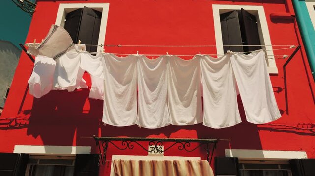 Red house facade with white laundry hanging outside